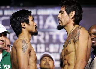 Filipino boxer Manny Pacquiao, left, and Antonio Margarito face off during the official weigh-in in Arlington,Texas Friday, November 12, 2010. Pacquiao weighed in at 144.6 lbs. Margarito weighed the contracted limit of 150 lbs.